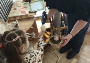 Dzieci przyklejają wydmuszki pod kontrola mamy Zosi