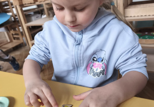 Dziewczynka wykleja ozdobę na kiermasz