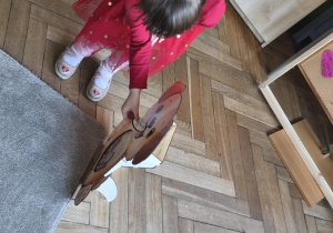 Na zdjęciu widzimy dziecko, które wkłada kartonik do "Głodomorka".