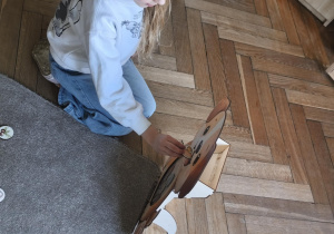 Na zdjęciu widzimy dziecko, które wkłada kartonik do "Głodomorka".