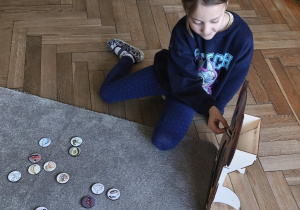 Na zdjęciu widzimy dziecko, które wkłada kartonik do "Głodomorka".