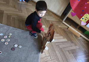 Na zdjęciu widzimy dziecko, które wkłada kartonik do "Głodomorka".