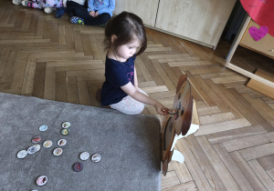 Na zdjęciu widzimy dziecko, które wkłada kartonik do "Głodomorka".