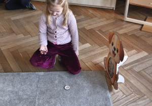 Na zdjęciu widzimy dziecko, które wkłada kartonik do "Głodomorka".