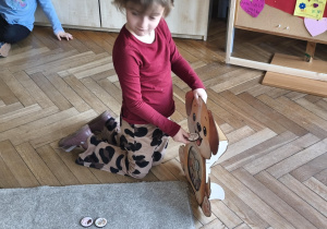 Na zdjęciu widzimy dziecko, które wkłada kartonik do "Głodomorka".