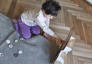 Na zdjęciu widzimy dziecko, które wkłada kartonik do "Głodomorka".