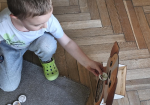 Na zdjęciu widzimy dziecko, które wkłada kartonik do "Głodomorka".