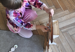 Na zdjęciu widzimy dziecko, które wkłada kartonik do "Głodomorka".