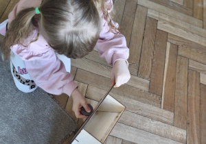 Na zdjęciu widzimy dziecko, które wkłada kartonik do "Głodomorka".