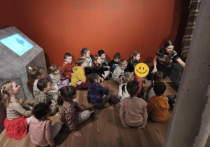 Na zdjęciu widzimy dzieci, które oglądają ekspozycję z butami pracowniczymi.