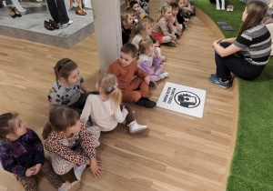 Na zdjęciu widzimy dzieci, które rozmawiają z panią Karoliną na temat rodzajów butów.