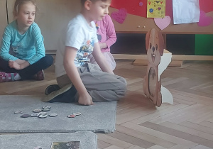 chłopiec sprawdza co pies może jeść wkładając wybrany produkt do jego mordki