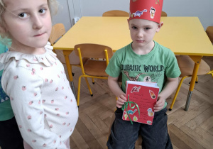 chłopiec w czerwonej koronie, trzyma laurki