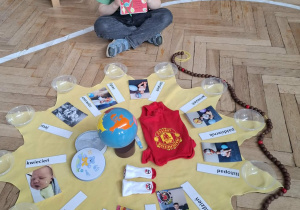 chłopiec w czerwonej koronie siedzi za urodzinowym słoneczkiem