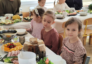 Zdjęcie przedstawia dzieci siedzące przy stole wielkanocnym.