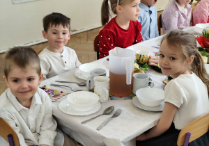 Dzieci siedzące przy wspólnym stole wielkanocnym