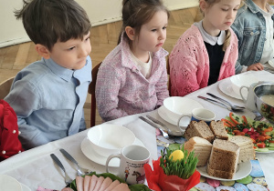 Dzieci siedzące przy stole wielkanocnym