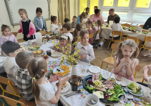 Na zdjęciu widzimy dzieci siedzące przy stole.