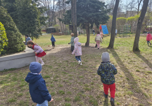 Na zdjęciu widzimy dzieci, które szukają jajeczek pochowanych przez Zajączka w ogródku przedszkolnym.