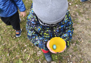 Na zdjęciu widzimy chłopca, który znalazł jajeczko pozostawione przez Zajączka.