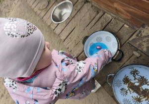 Na zdjęciu widzimy dziewczynkę, która znalazła jajeczko w kuchni błotnej.