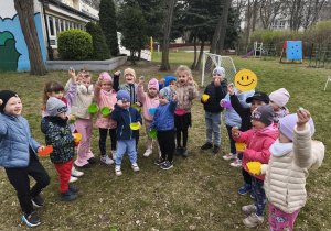 Na zdjęciu widzimy grupkę dzieci, które odnalazły czekoladowe jajka od Zajączka.