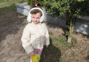 Na zdjęciu widzimy dziewczynkę, która w ręku trzyma miseczkę z jajkiem.