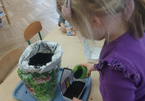 dziewczynka tworzy swój ogródek przy domku