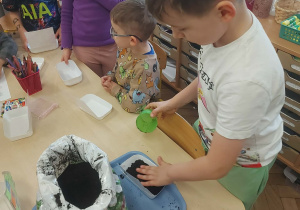 chłopiec tworzy swój ogródek przy domku