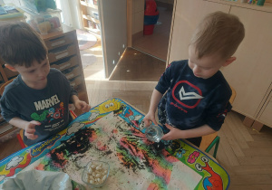 chłopcy sadzą cebulki kwiatów