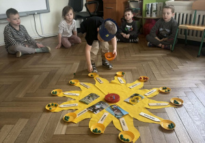 Chłopiec rozkłada koraliki na "słoneczku urodzinowym".