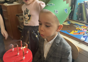 Chłopiec zdmuchuje świeczki.