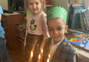 Zdjęcie przedstawia chłopca przy torcie ze świeczkami.