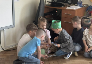 Chłopiec pokazuje zdjęcia innym dzieciom.