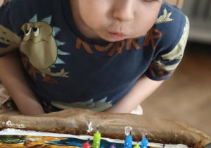Kacper dmucha świeczki na torcie
