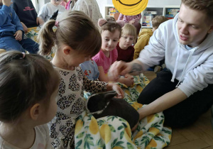 Na zdjęciu widzimy dzieci, które opiekują się królikami.