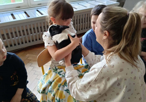 Na zdjęciu widzimy dziewczynkę, która przytula królika.