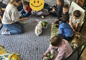 Na zdjęciu widzimy dzieci, które opiekują się królikami.
