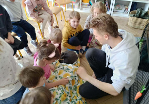 Na zdjęciu widzimy dzieci, które opiekują się królikami.