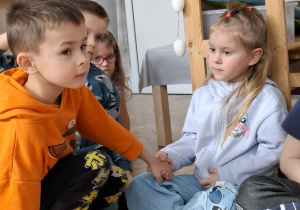 dzieci podają sobie ręcę na zgodę