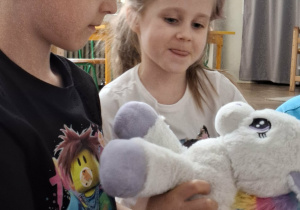 chłopiec trzyma maskotkę jednorożca