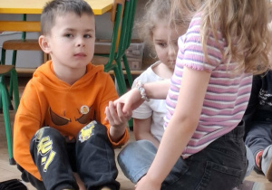 dzieci podają sobie ręcę na zgodę