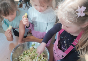 Dziewczynki mieszają sałatkę owocową.