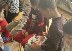 Chłopiec ogląda zabawkę drewnianą dla krókików.