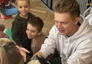 Na zdjęciu mężczyzna daje dziewczynce królika.