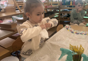 Zdjęcie przedstawia dziewczynkę, która rwie watę.