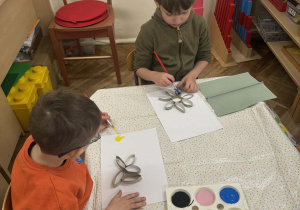 Na zdjęciu widać dzieci malujące farbami swoje prace.