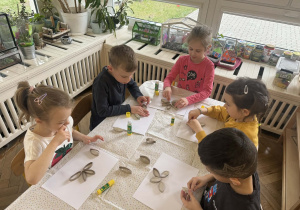 Zdjęcie przedstawia dzieci tworzące swoje kwiatki z rolek po papierze toaletowym.