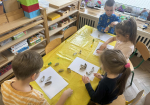 Zdjęcie przedstawia dzieci tworzące swoje kwiatki z rolek po papierze toaletowym.