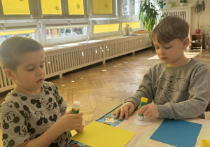 Zdjęcie przedstawia dzieci podczas wykonywania pisanki.